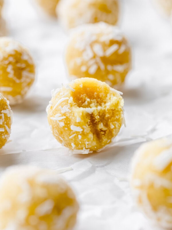 a lemon bliss ball with a bite taken out of it