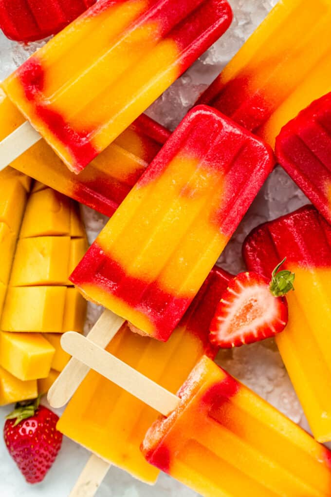 strawberry mango popsicles stacked on ice