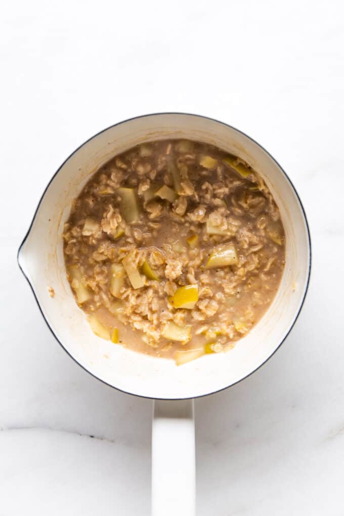 apple pie oatmeal cooking in a white pot