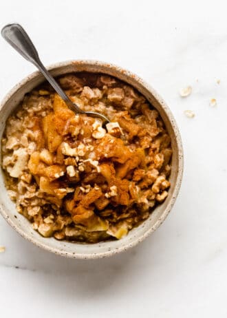 cinnamon apple pie oatmeal with a spoon in a bowl