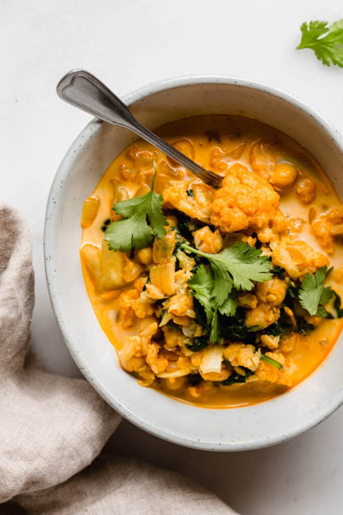 cauliflower curry in a bowl with a spoon