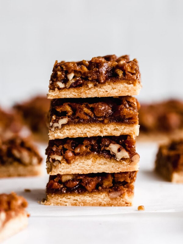 a stack of four pecan pie bars on a marble board