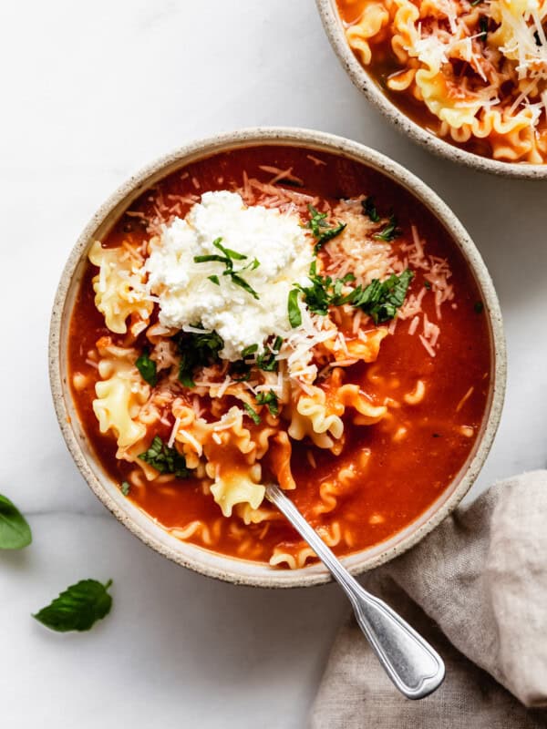 lasagna soup in a bowl topped with ricotta and basil