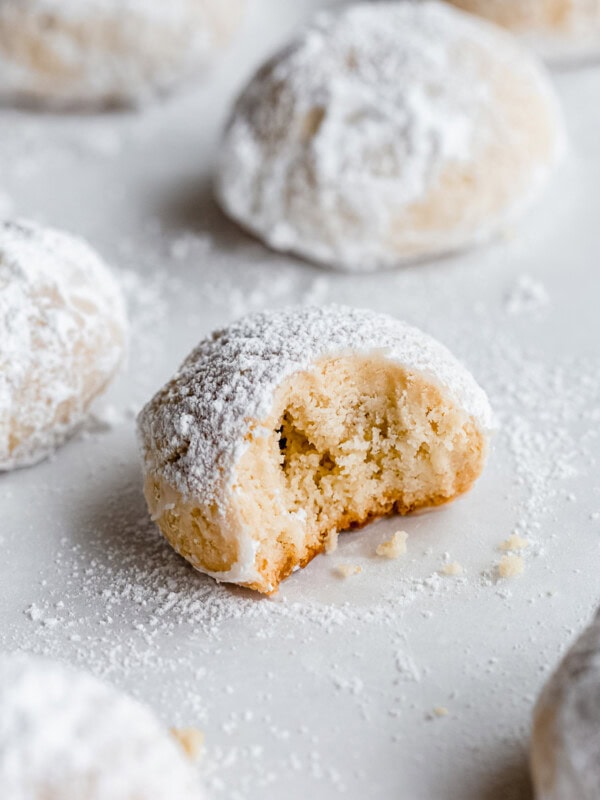 an almond snowball cookie with a bite taken out of it
