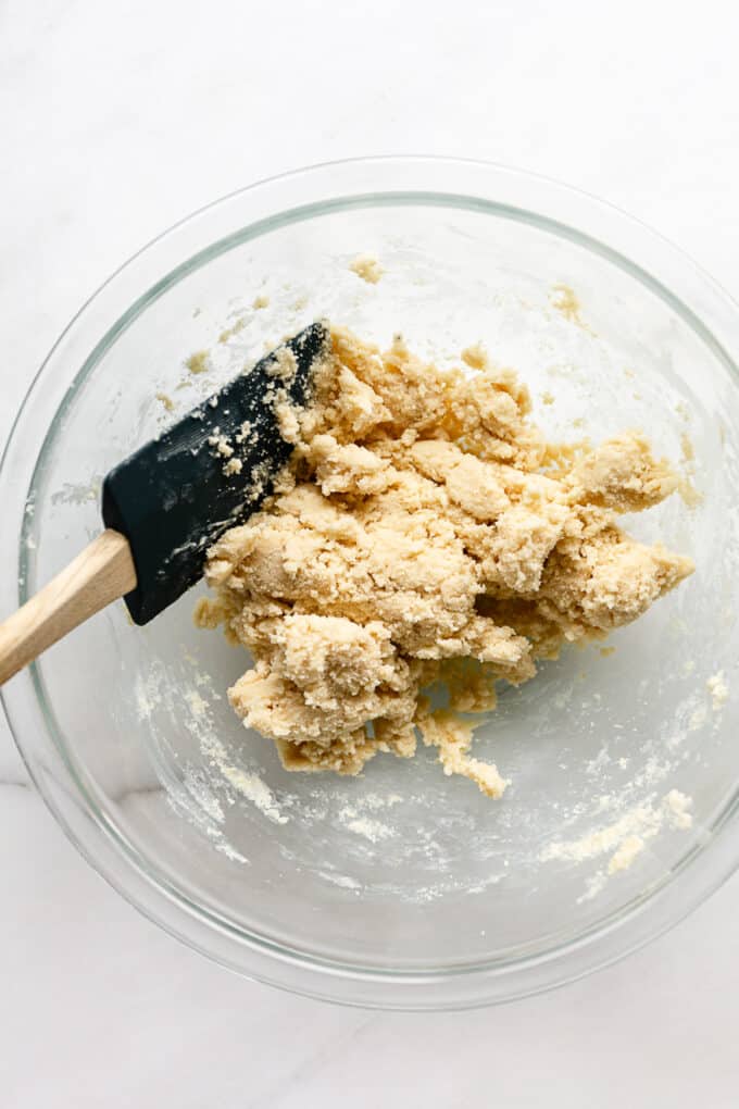 almond snowball cookie dough in a mixing bowl