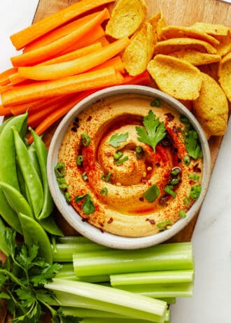 buffalo hummus on a wood board with vegetables and chips