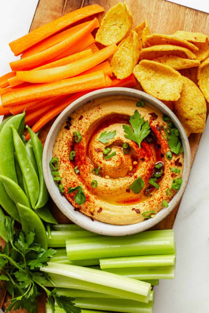 buffalo hummus on a wood board with vegetables and chips