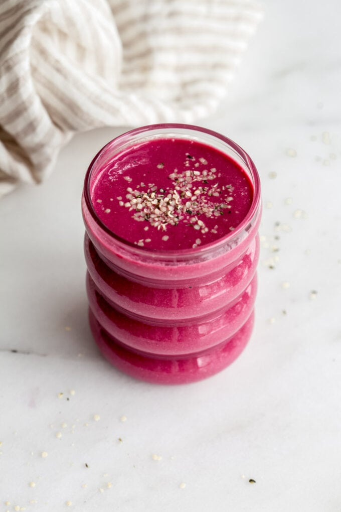 a beet smoothie with hemp seeds on a marble counter