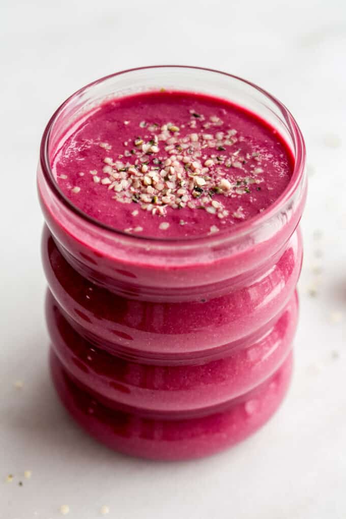 A beet smoothie in a glass topped with hemp seeds
