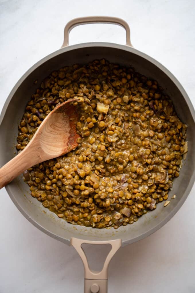 curried green lentils cooking in a large pan