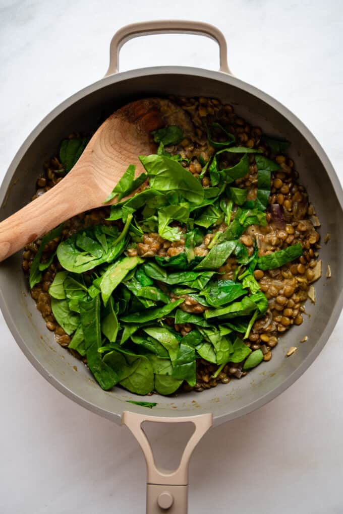 green lentil curry and spinach in a large pan