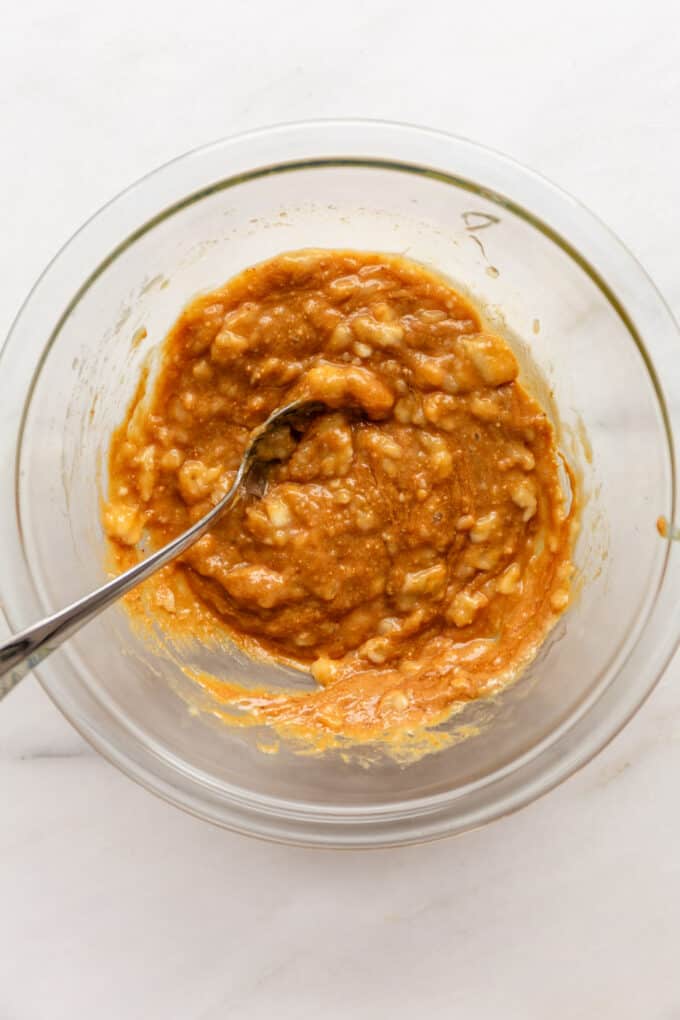 mashed banana mixed with peanut butter and honey in a mixing bowl