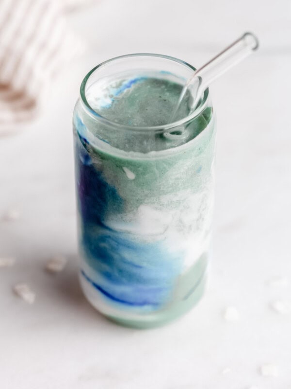 blue spirulina smoothie in a glass with a straw