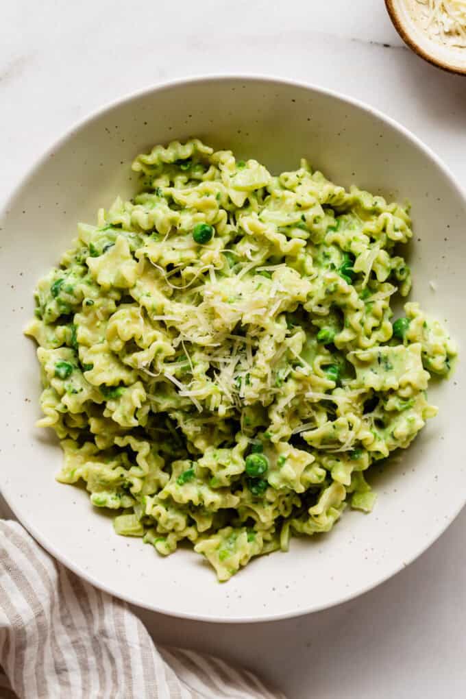 ricotta and pea pasta in a bowl topped with parmesan cheese