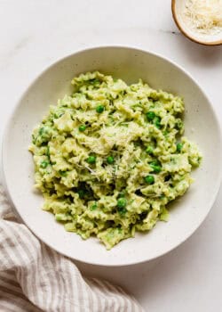 ricotta and pea pasta in a bowl with a striped napkin on the side