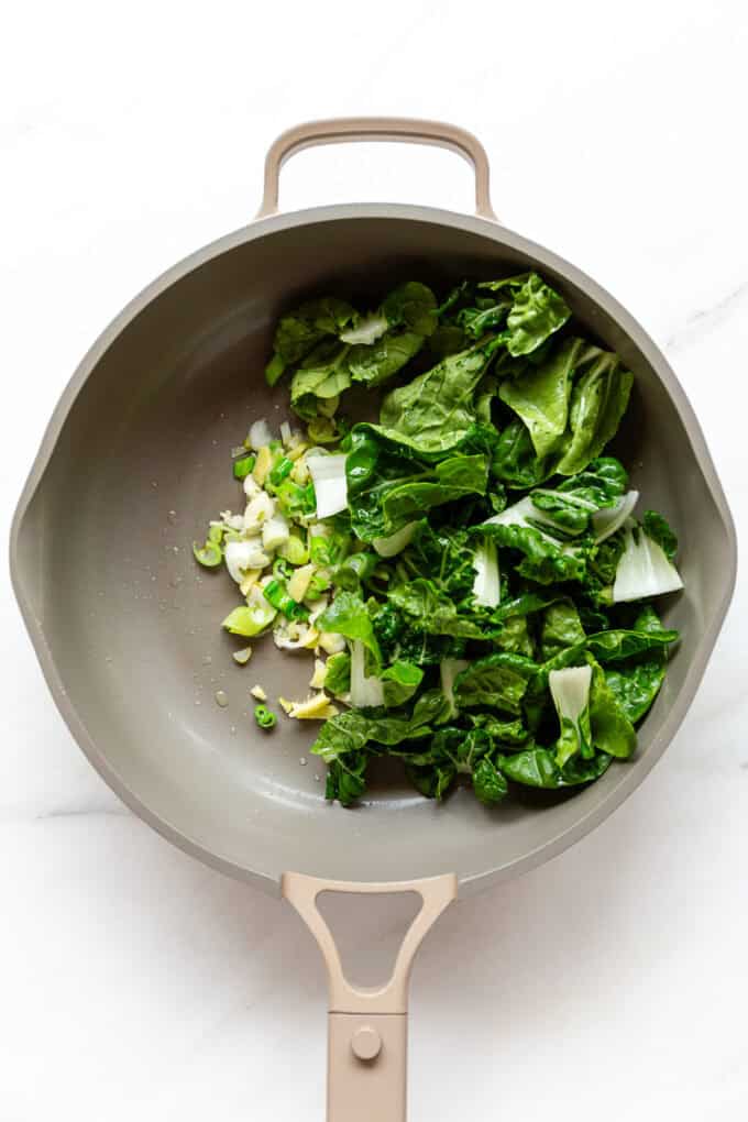 green onion, ginger, garlic and bok choy in a pan