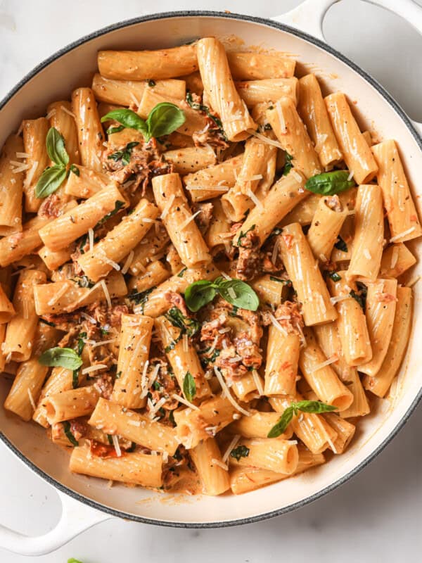 a pot of rigatoni in sundried tomato sauce with basil