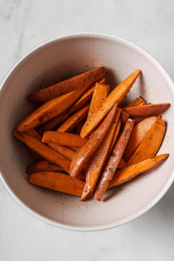 sliced sweet potatoes in a clear mixing bowl