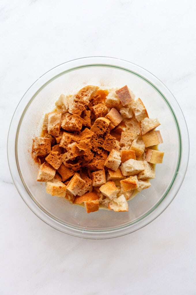 cubed bread with cinnamon in a mixing bowl