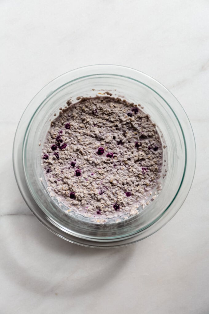 blueberry overnight oats in a clear mixing bowl.