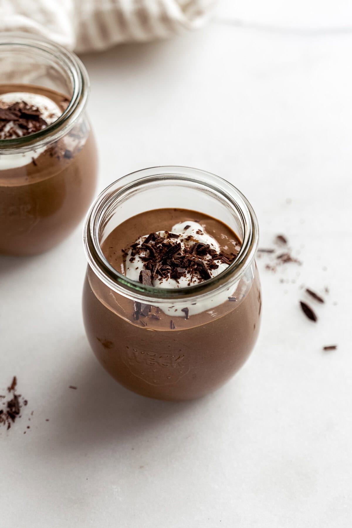 cottage cheese chocolate mousse in a small jar with yogurt and chocolate on top.