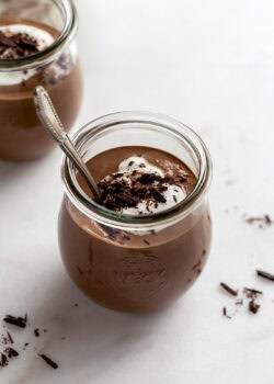 A cup of cottage cheese chocolate mousse topped with yogurt and chocolate shavings.