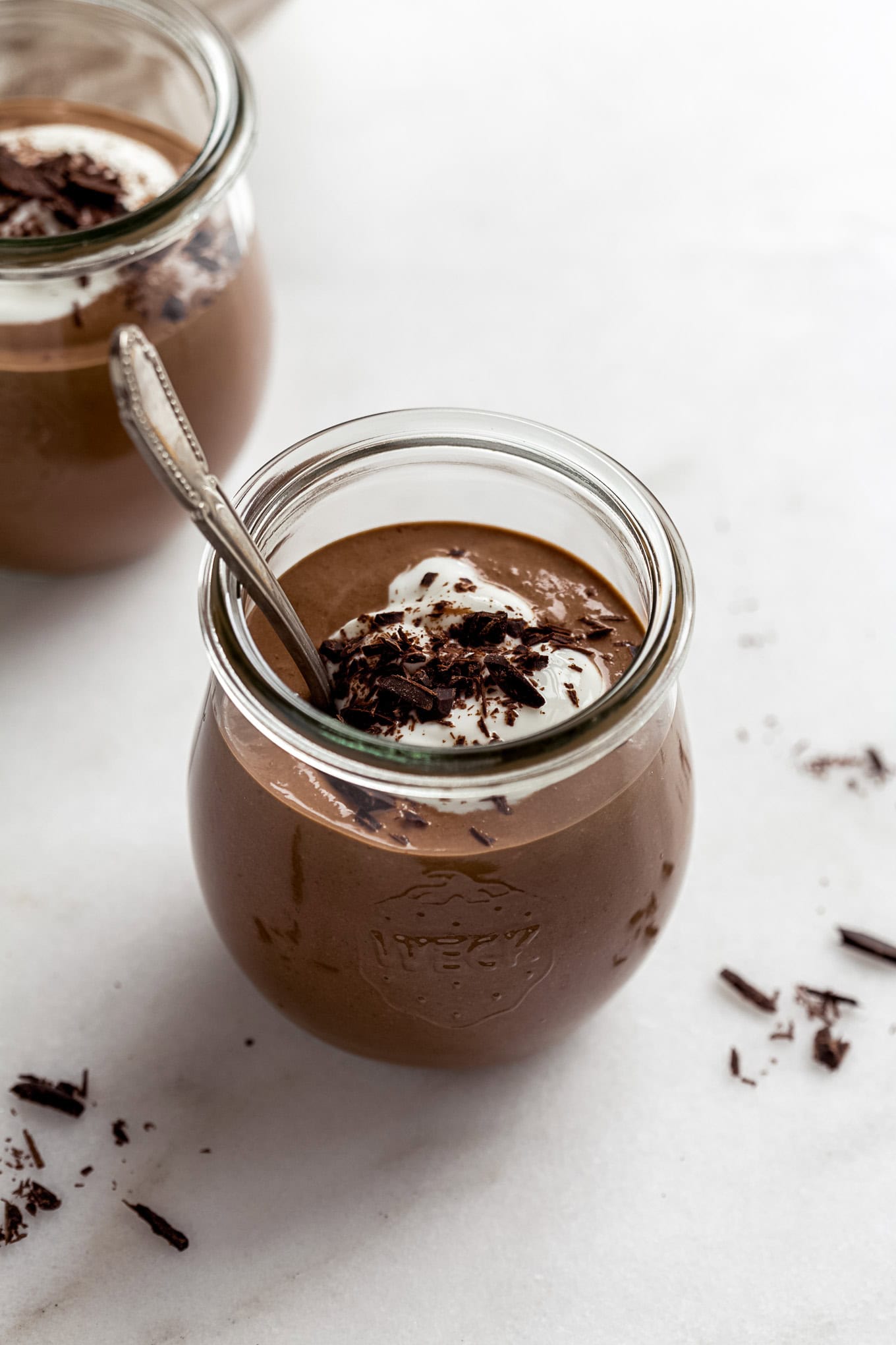 A cup of cottage cheese chocolate mousse topped with yogurt and chocolate shavings.
