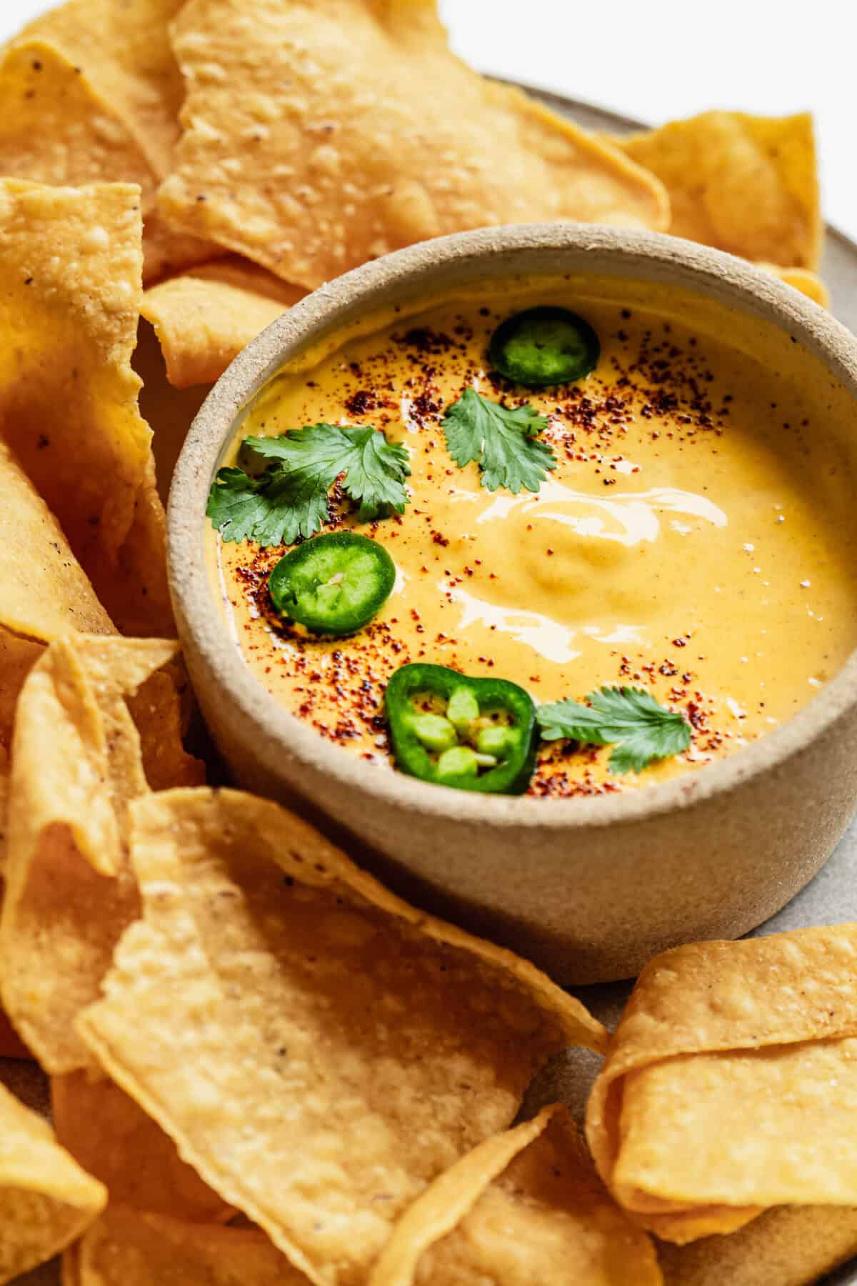 Cottage cheese queso with tortilla chips on a plate.