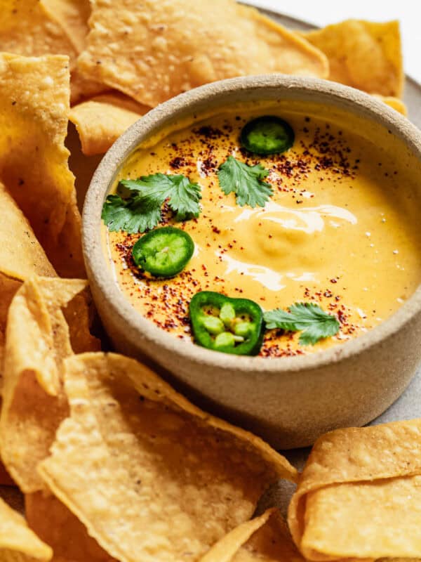 Cottage cheese queso with tortilla chips on a plate.
