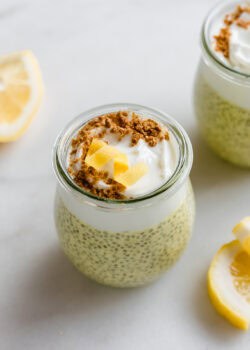 A cup of lemon chia pudding topped with yogurt, graham cracker crumbs, and a lemon twist.