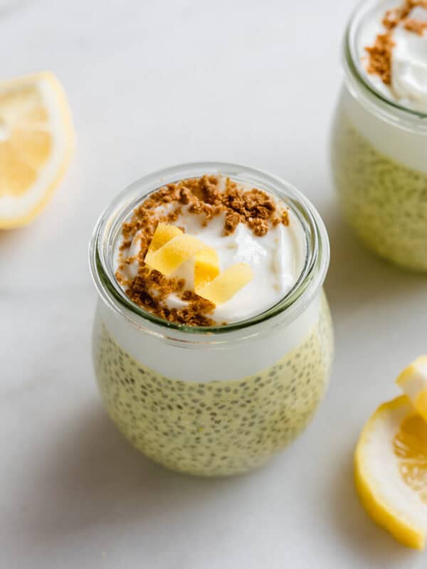 A cup of lemon chia pudding topped with yogurt, graham cracker crumbs, and a lemon twist.