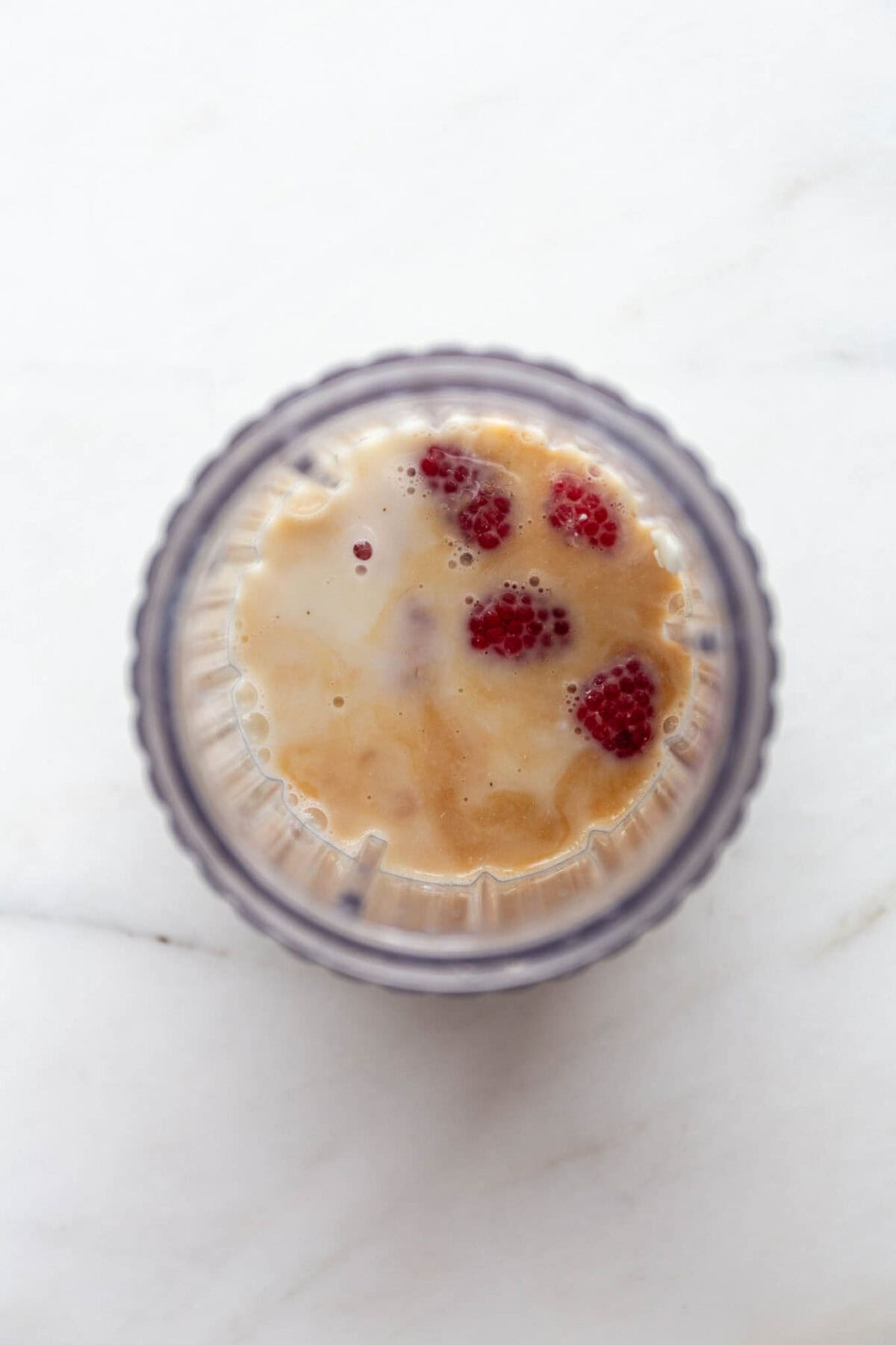 cottage cheese, raspberries, maple syrup and vanilla in a blender container.