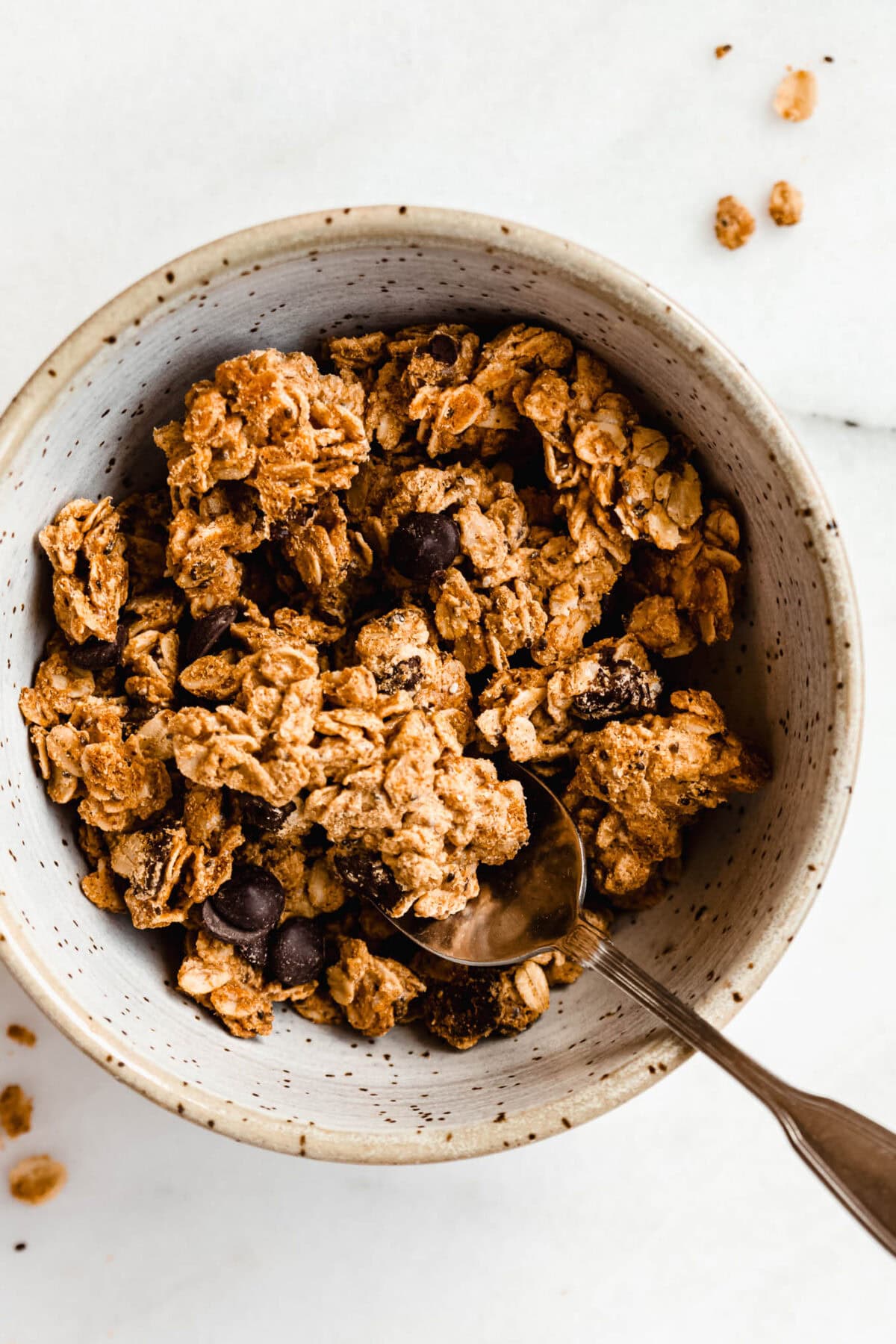 a bowl of cookie dough granola with a spoon in it.