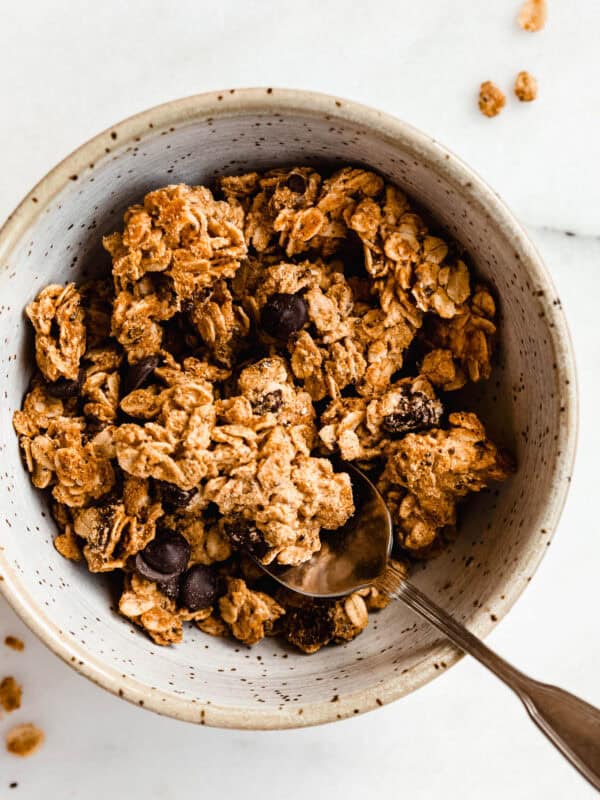 a bowl of cookie dough granola with a spoon in it.
