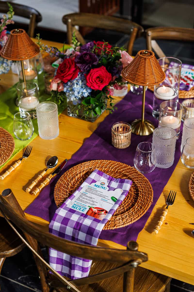 a pruple napkin and place setting at a table.