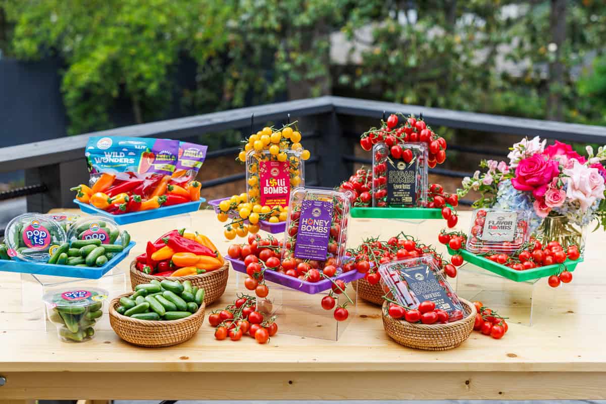 cherry tomatoes, peppers and cucumbers on a table.