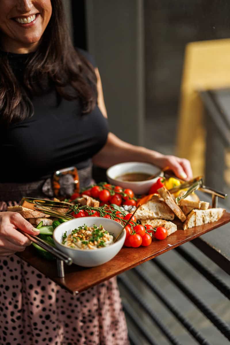 a person holding a tray of crudite.