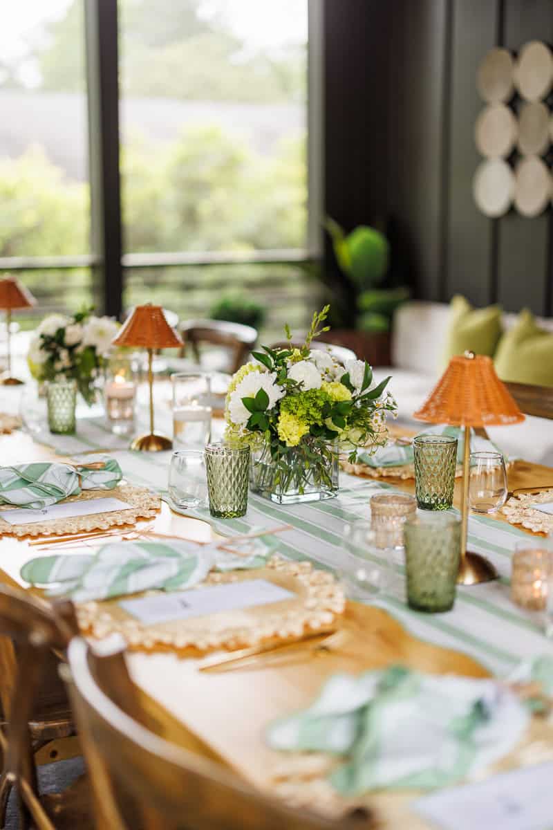 a tablescape with flowers and green pace settings.