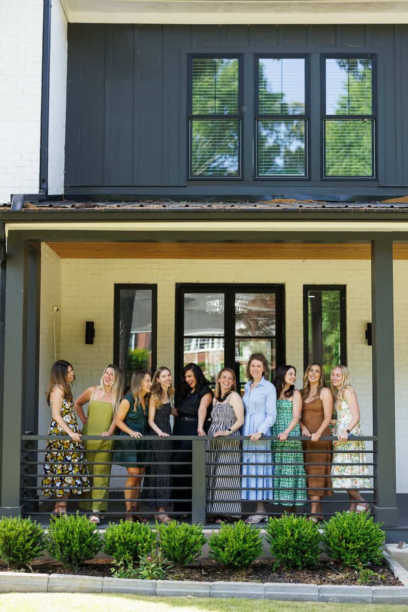 a group of girls laughing on a front porch.