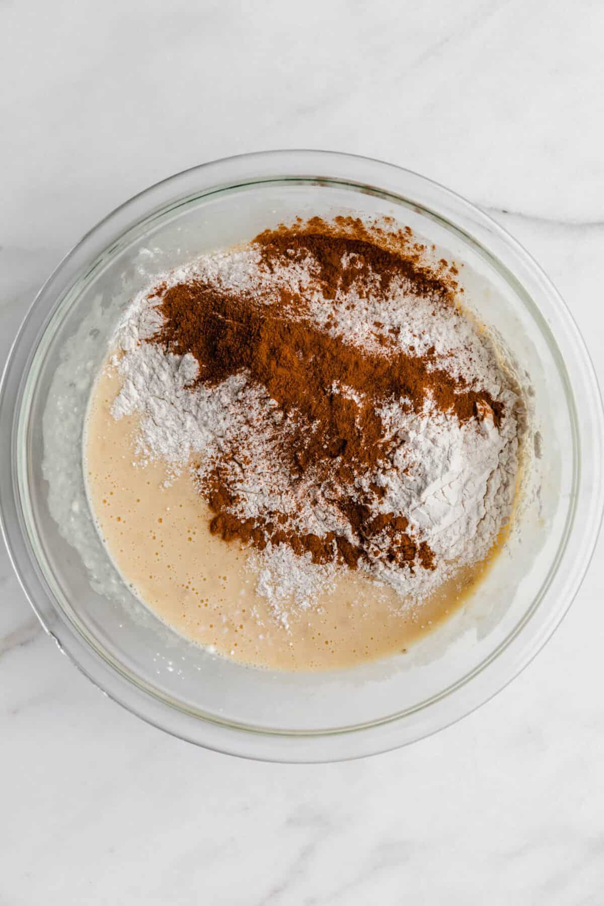wet and dry ingredients for banana cottage cheese muffins in a mixing bowl.
