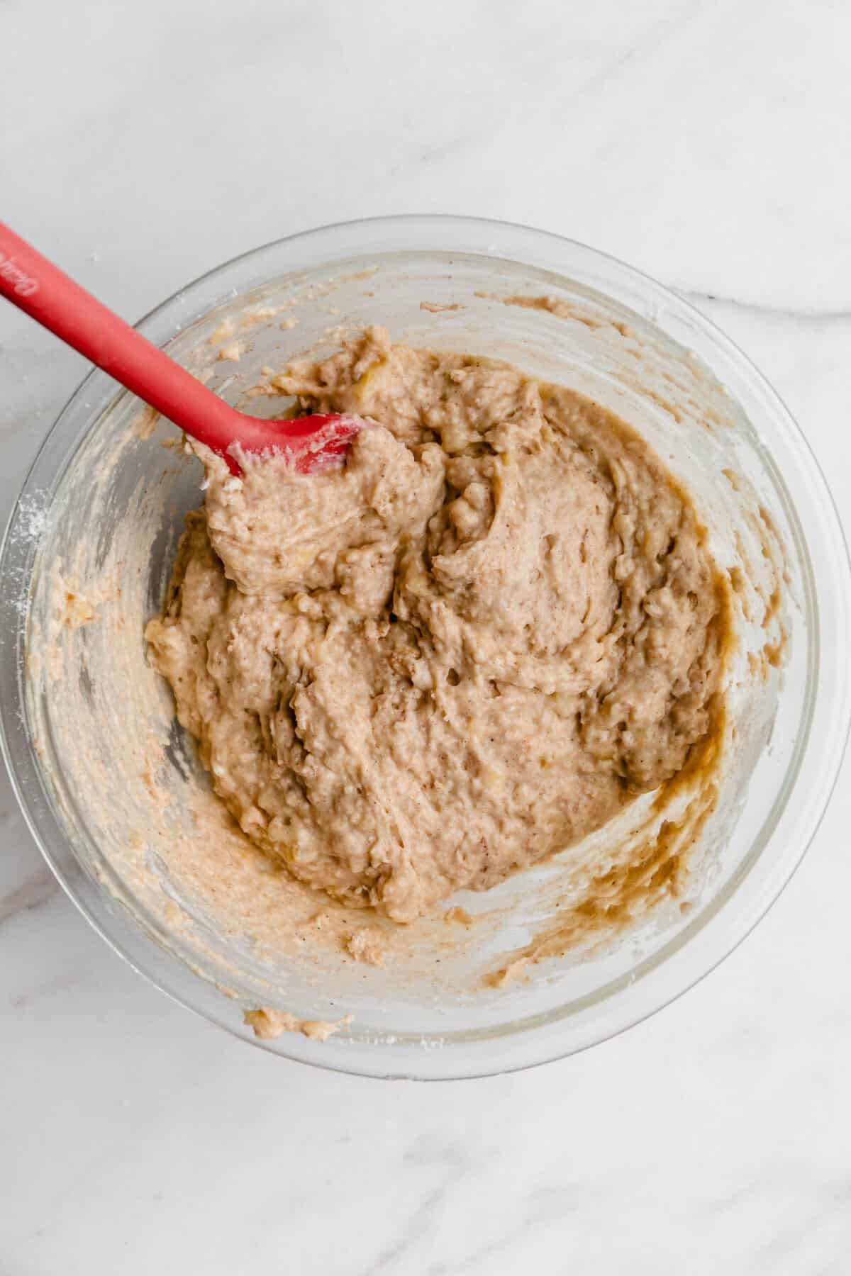cottage cheese banana muffin batter in a clear mixing bowl.