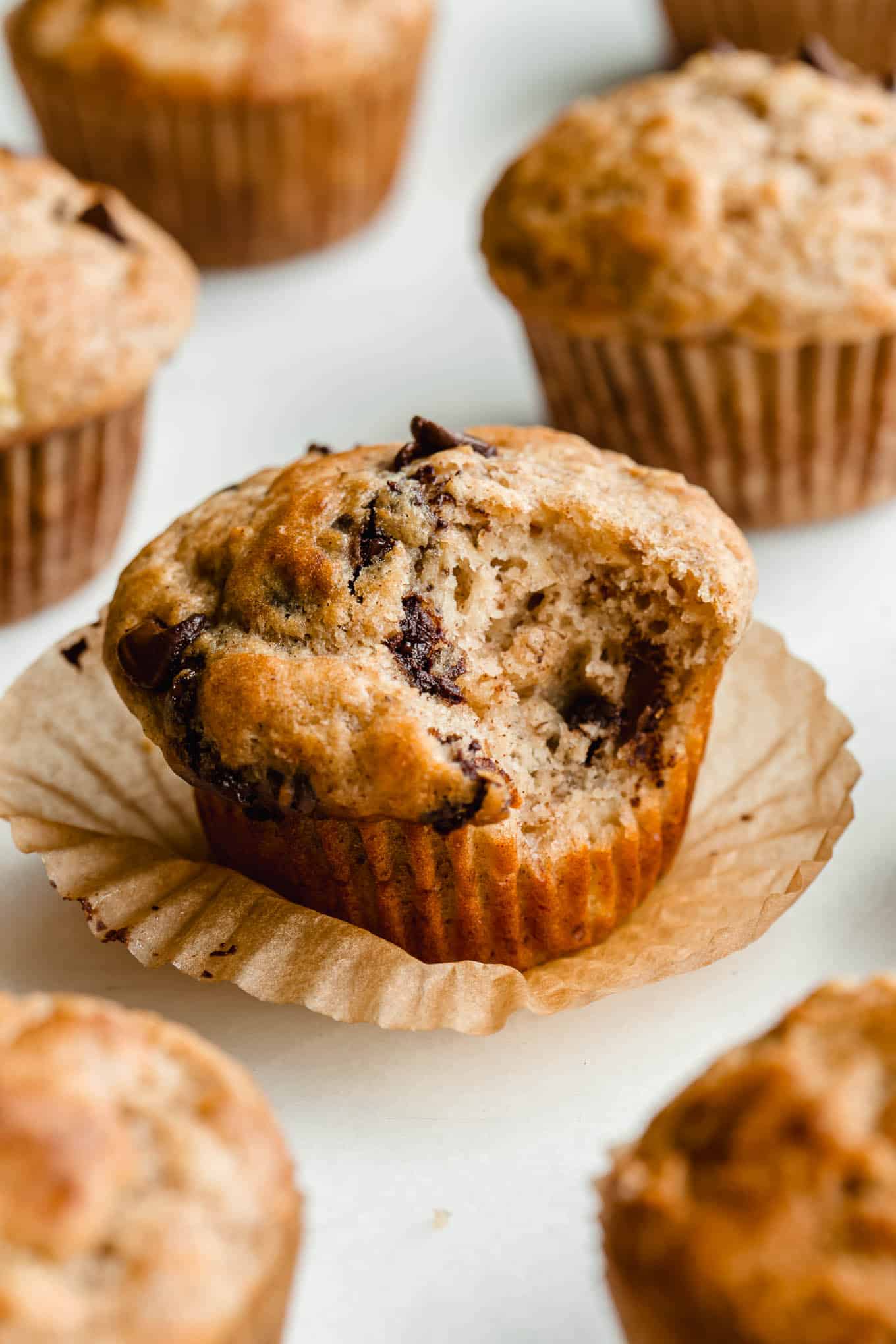 A cottage cheese banana muffins with chocolate chips with a bite taken out of it.