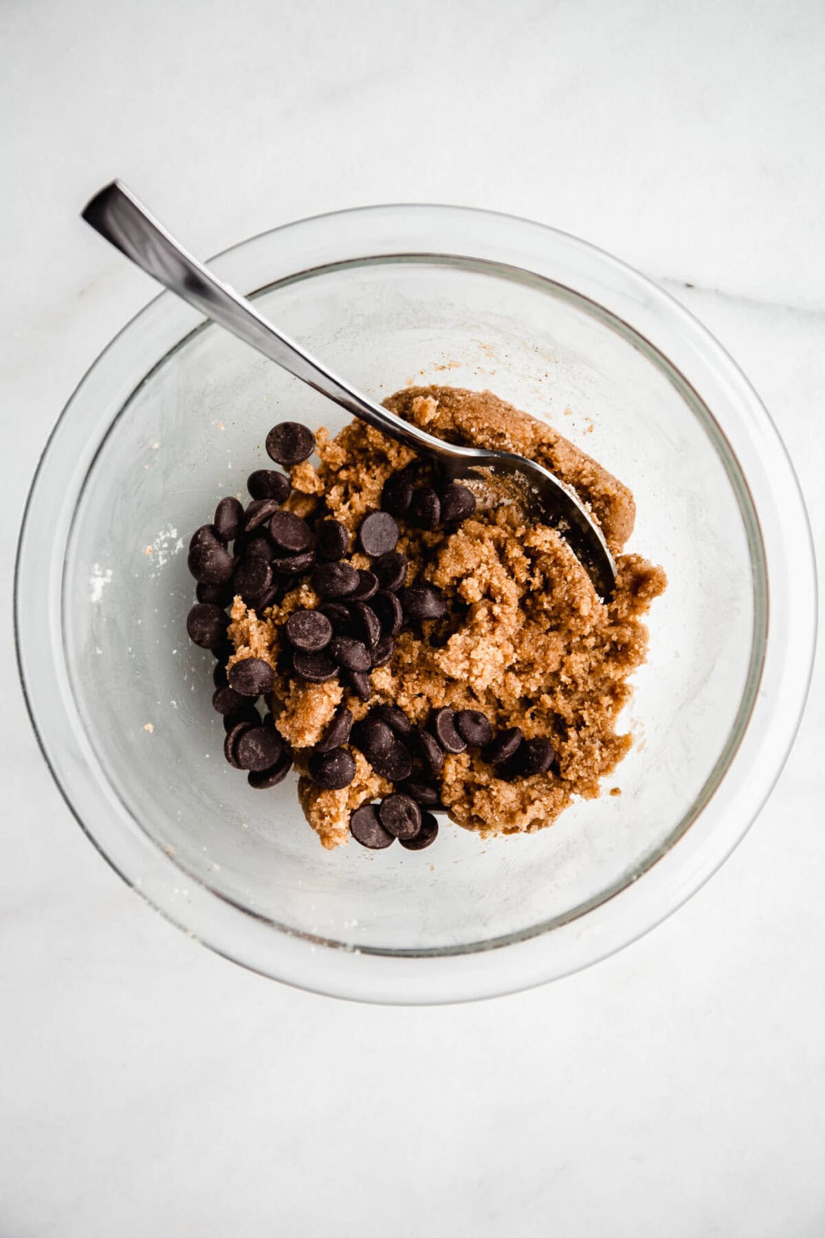 no bake cookie dough with chocolate chips in a mixing bowl with a spoon.