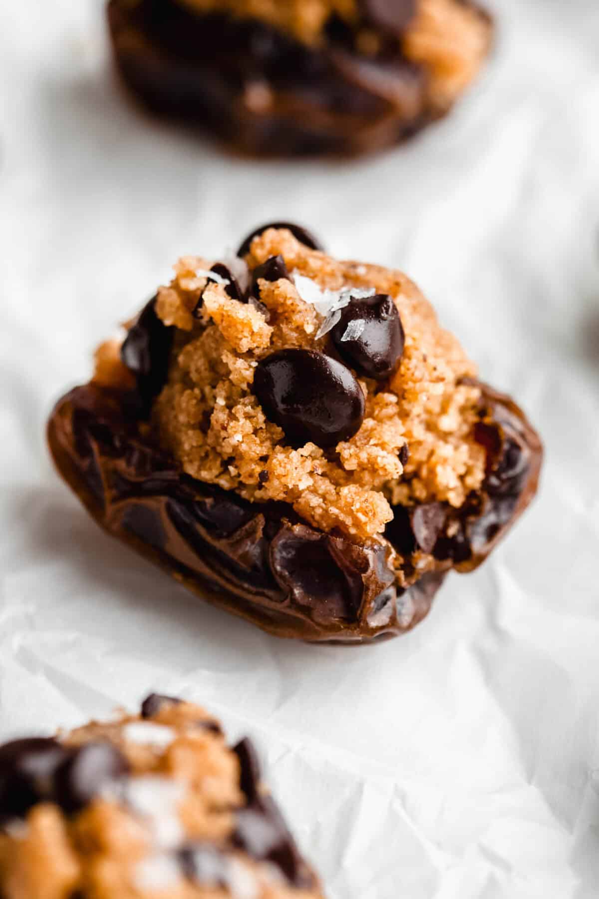 a cookie dough stuffed date on parchment paper.