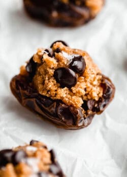 a cookie dough stuffed date on parchment paper.