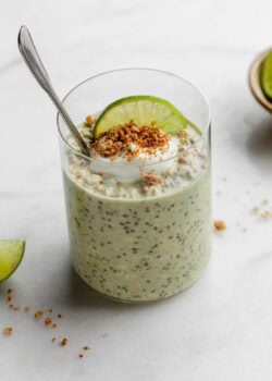 Key lime pie overnight oats topped with yogurt and graham cracker crumbs with a spoon in it.
