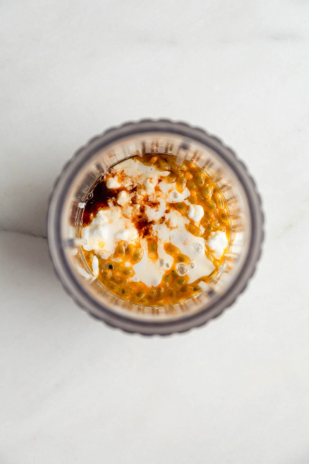 Passionfruit chia pudding in a glass jar topped with yogurt and passionfruit pulp