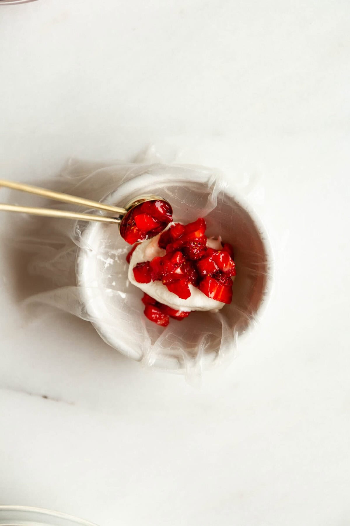 Strawberry being placed into rice paper dough to make rice paper mochi