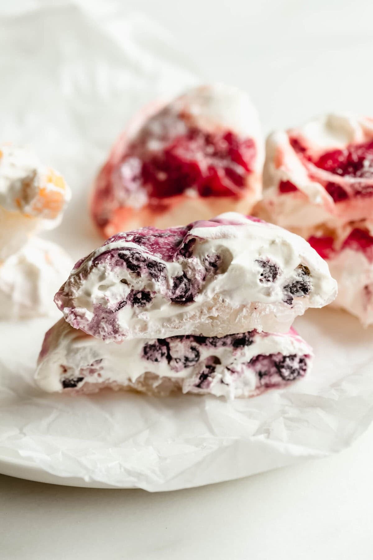 Rice paper mochi cut open to reveal blueberry filling, with mango and strawberry mochi in background