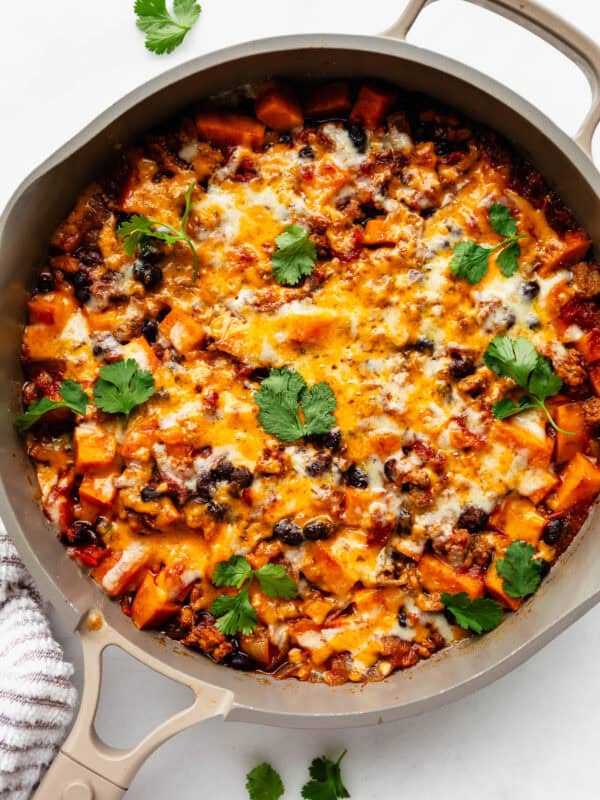 ground turkey sweet potato skillet topped with melted cheese and cilantro.